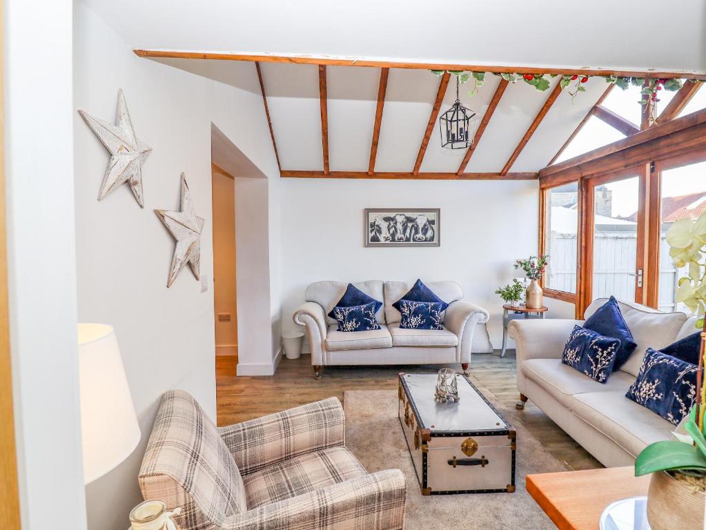 a living room with two couches and a table at Church View Cottage in Doncaster