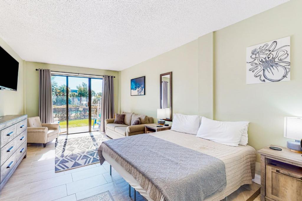 a bedroom with a bed and a living room at Pirates Bay B109 in Fort Walton Beach