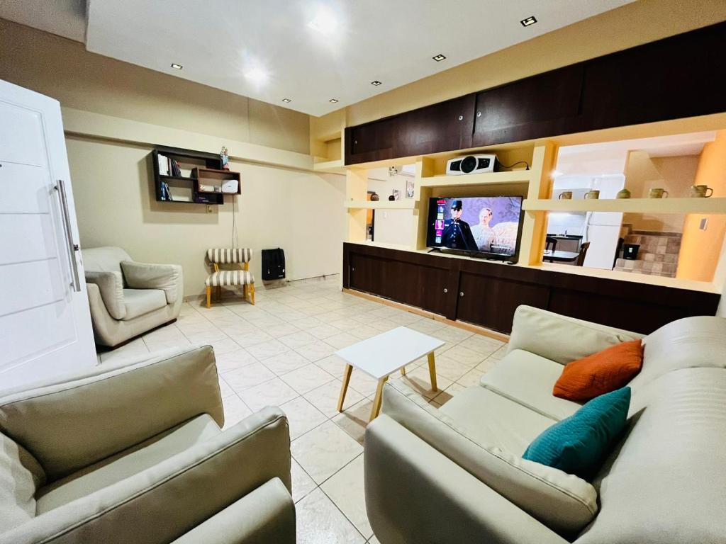 a living room with couches and a flat screen tv at Duplex Centrico in Termas de Río Hondo