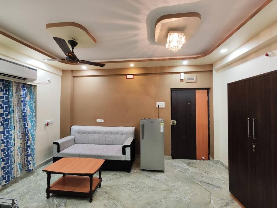 - un salon avec un canapé et une table dans l'établissement Stylish 2BHK Service Apartment Near Golpark, à Kolkata