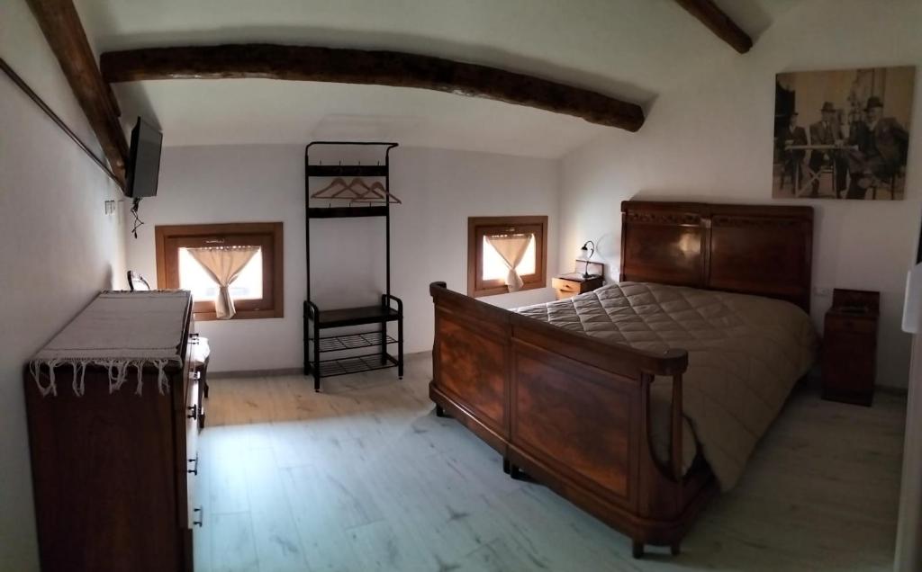 1 dormitorio con 1 cama grande y 2 ventanas en Bevi e Dormi, en Monteforte dʼAlpone