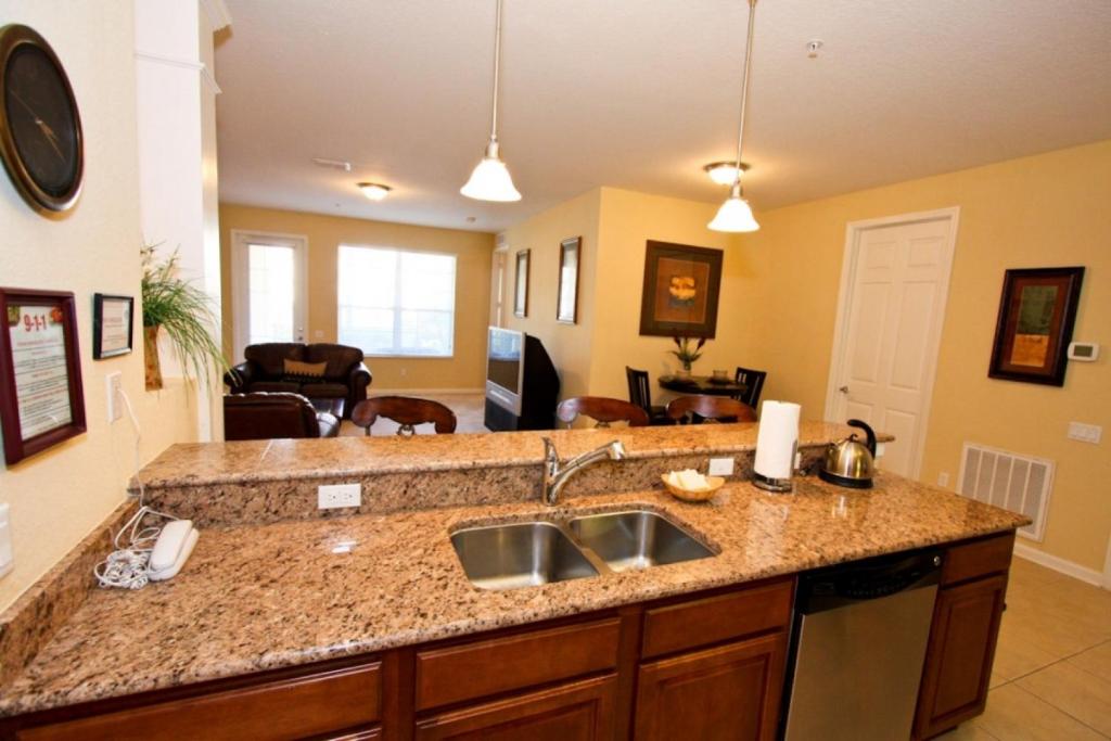 a kitchen with a sink and a living room at IT212 - Vista Cay Resort - 2 Bed 2 Baths Condo in Orlando
