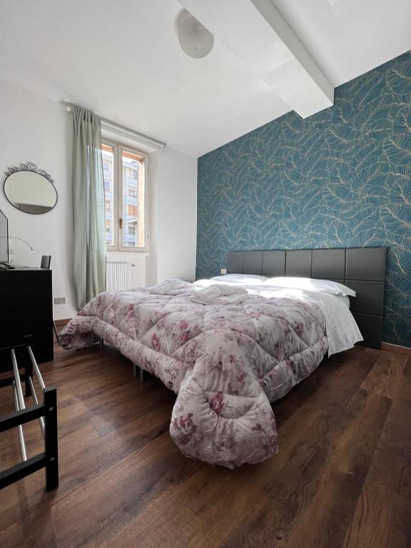 een slaapkamer met een groot bed en een blauwe muur bij Hotel Brenta in Parma