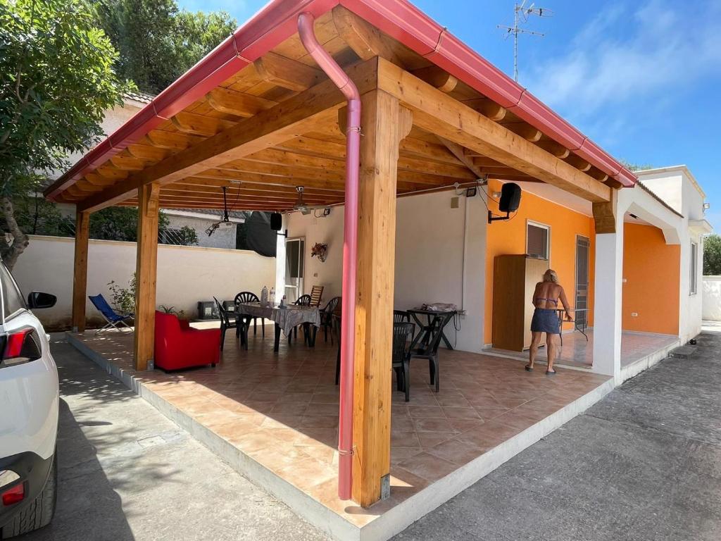- un pavillon en bois avec une table et une femme qui entre dans une maison dans l'établissement Villetta Carmelo, à San Pietro in Bevagna