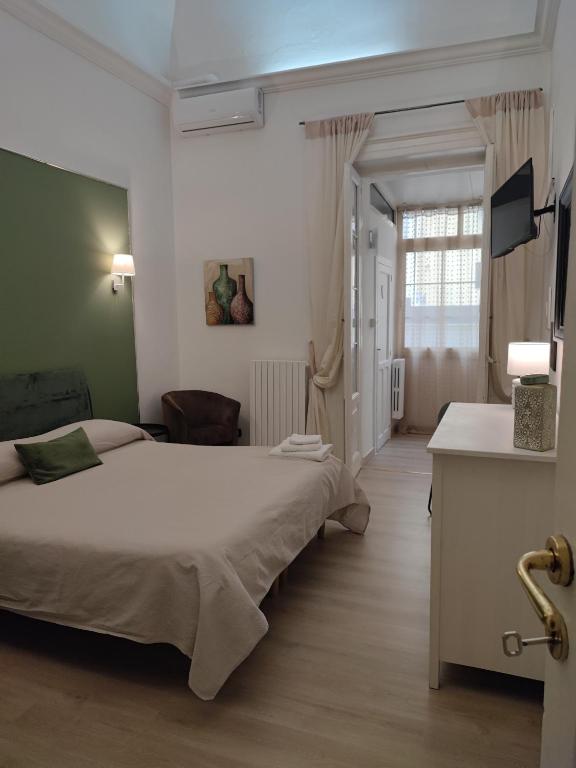 sypialnia z łóżkiem, biurkiem i telewizorem w obiekcie Casa Decò Business Stay Solution w mieście Tarent