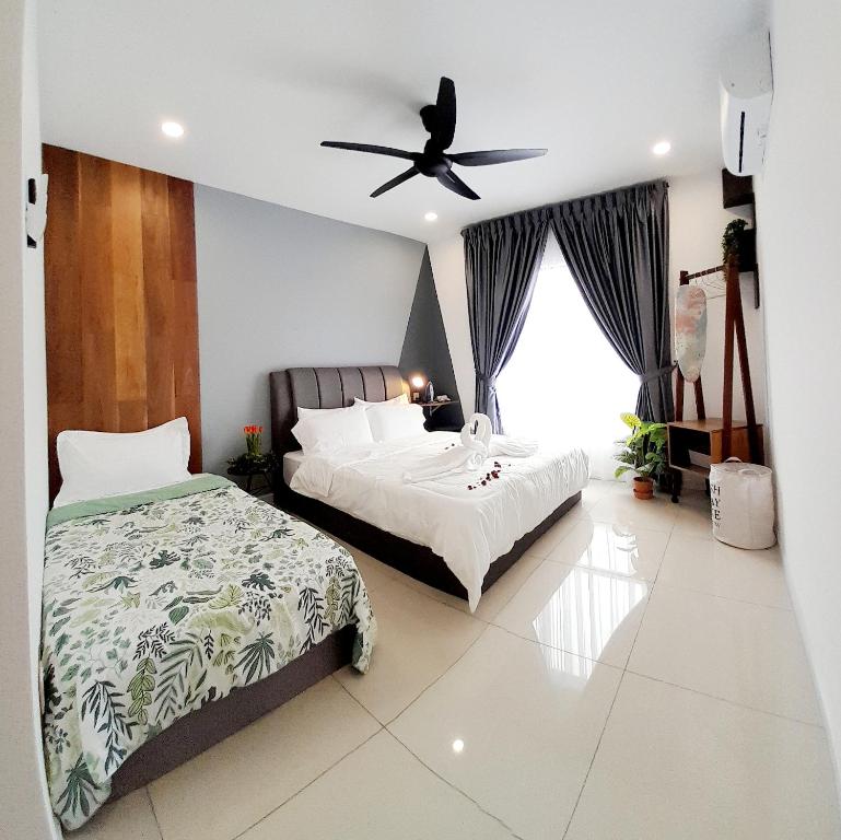 a bedroom with two beds and a ceiling fan at Ipoh Homestay - Manhattan Condominium with Water Park & Leisure Facilities in Ipoh