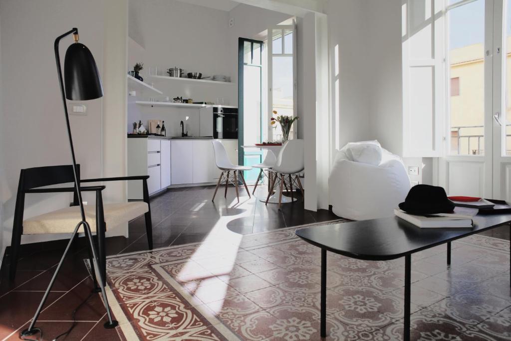 a living room with a table and white chairs at Carolina's Nest in Trapani