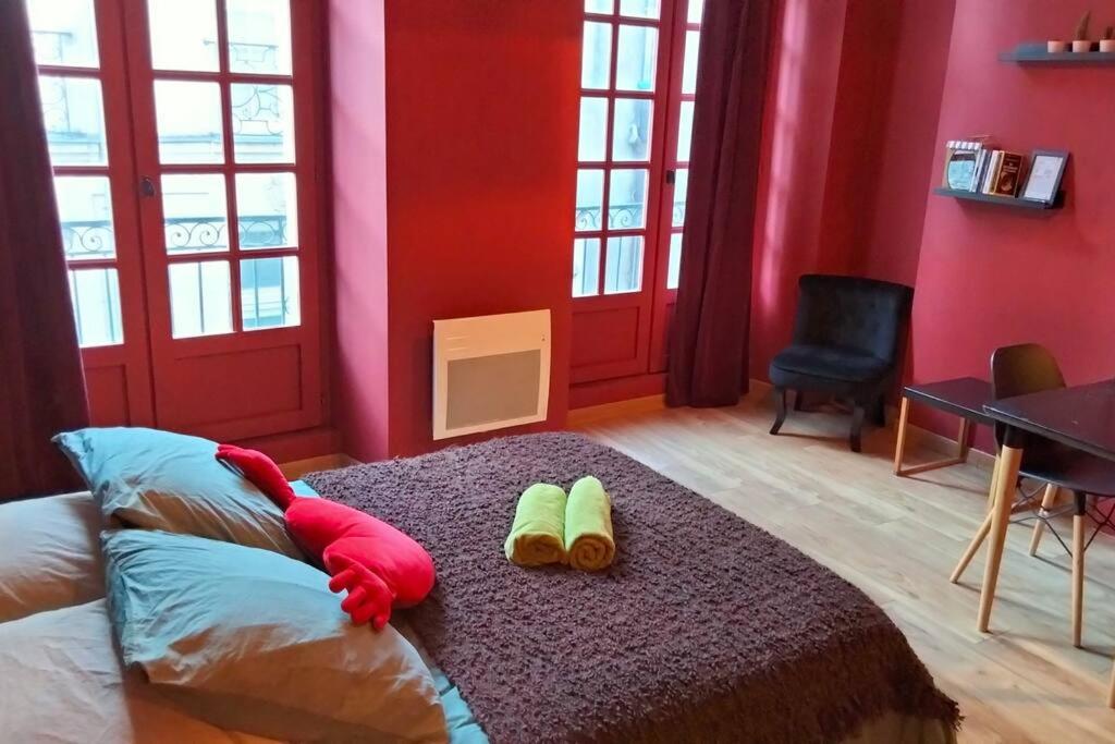 um quarto com paredes vermelhas e uma cama com 2 chinelos em Le Pillow Rit em Nantes