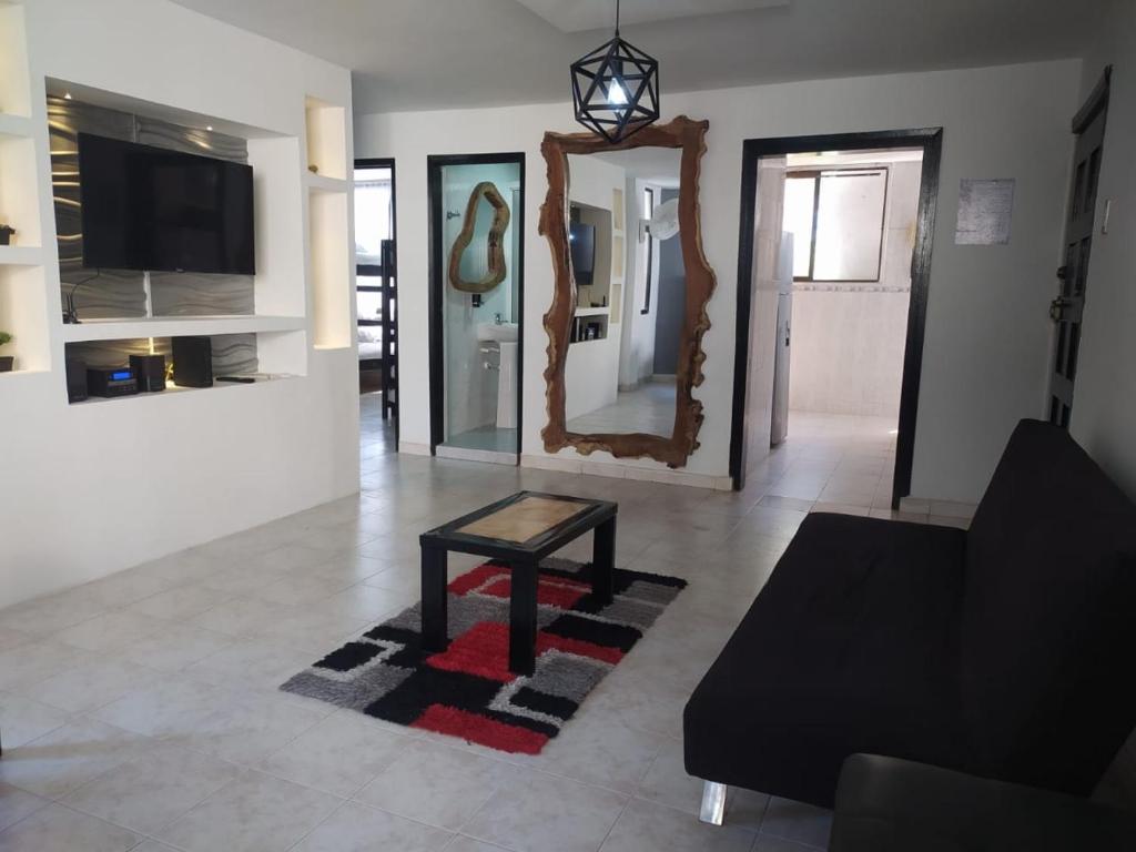 a living room with a table and a mirror at Hermoso apto a una cuadra de la playa rodadero in Gaira