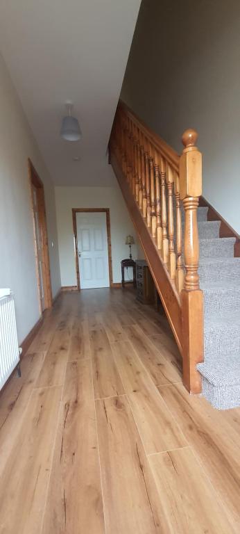Habitación vacía con escalera y suelo de madera. en Carrick-On-Shannon Townhouse Accommodation - Room only, en Carrick on Shannon