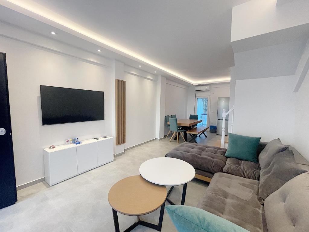 a living room with a couch and a table at Sunrise Luxury House in Pefkochori