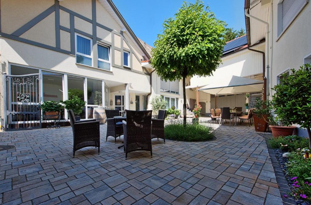 eine Terrasse mit Stühlen und einem Tisch vor einem Gebäude in der Unterkunft Gästehaus Schmitt in Appenheim