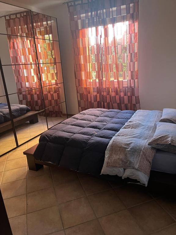 1 dormitorio con 1 cama y 2 ventanas en La Casa del Ciarlatano, en Cerreto di Spoleto