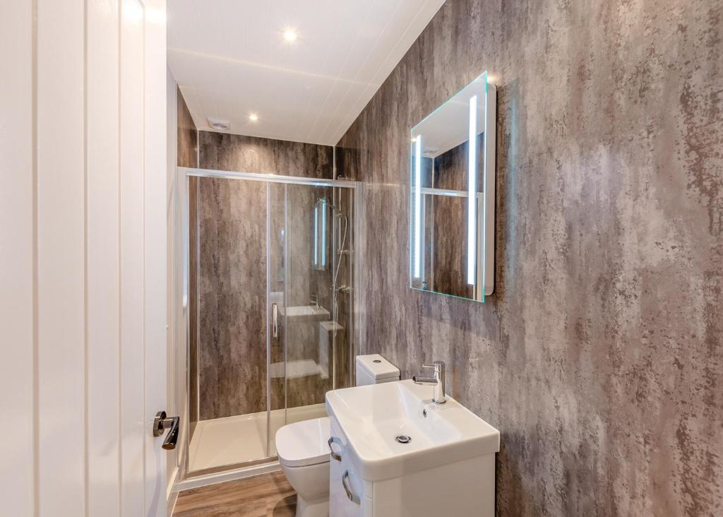 uma casa de banho com um lavatório, um WC e um espelho. em Hambleton Lakeside Lodges em Poulton le Fylde