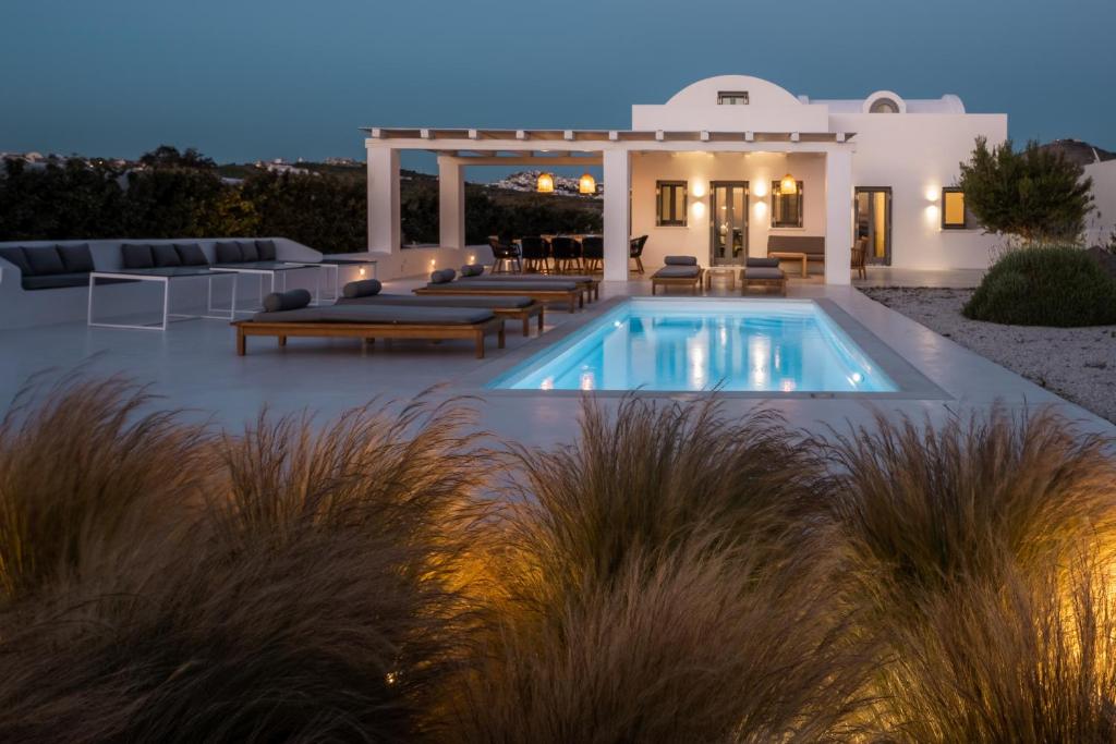 a villa with a swimming pool at night at Philosophia Luxury Villa in Megalochori
