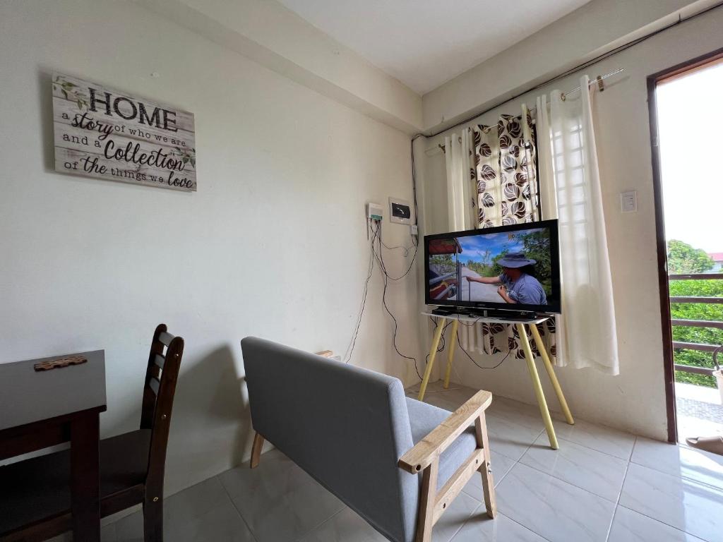 sala de estar con TV y silla en Reinhardshausen Suites and Residences - Cozy Air-conditioned Units en Tuguegarao