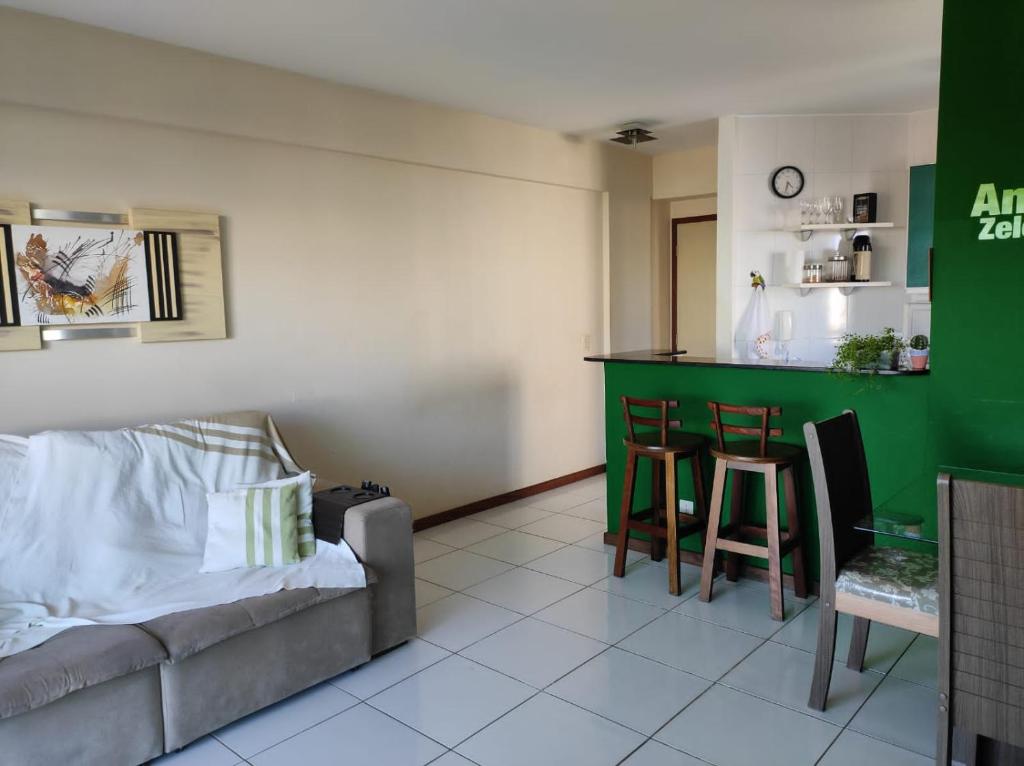 a living room with a couch and a green bar at Seu Apê na Enseada Azul - Bacutia !!! in Guarapari