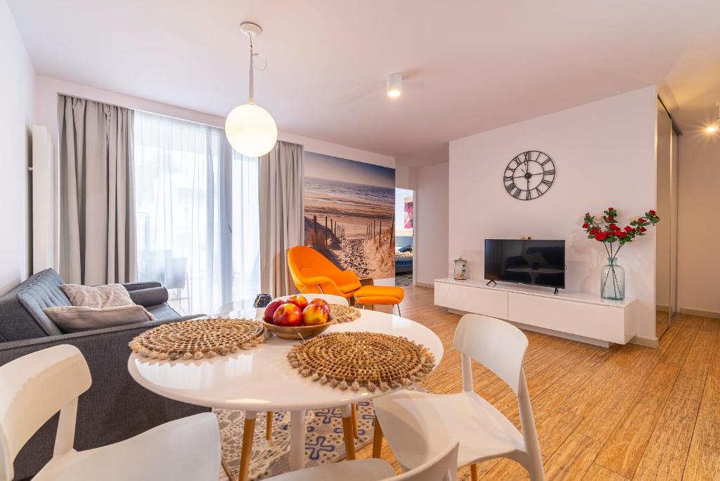 a living room with a couch and a table and chairs at Apartament DREAM in Pogorzelica