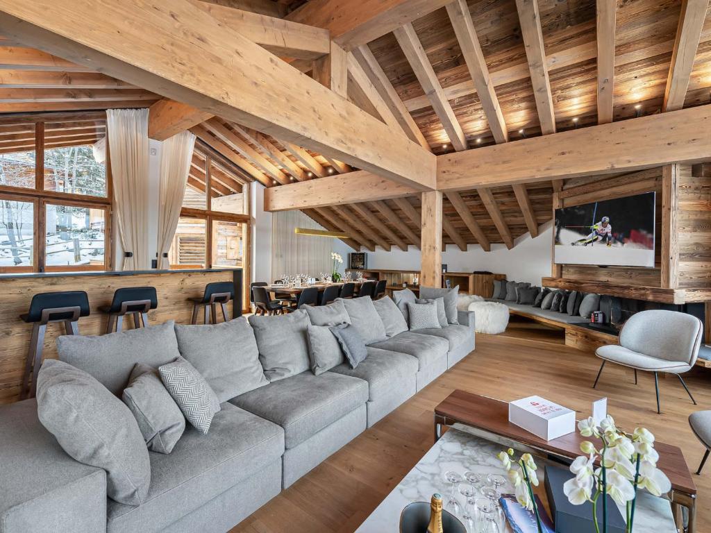 salon z dużą kanapą i telewizorem w obiekcie Chalet Neuf avec Piscine, Sauna et Proche des Pistes à Courchevel Village - FR-1-562-47 w Courchevel