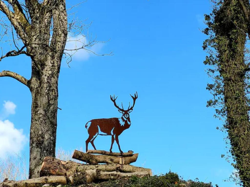 una statua di un cervo in piedi su un mucchio di rocce di The Hideaway a Shepton Mallet