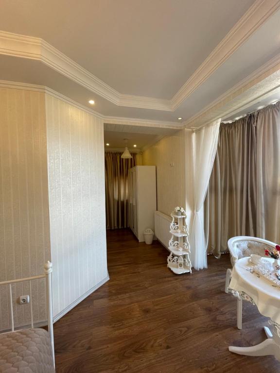 Ami Residence Bucharest Airport,Therme&FREE PARKING Otopeni في أوتوبيني: غرفة معيشة مع غرفة بيضاء كبيرة مع طاولة