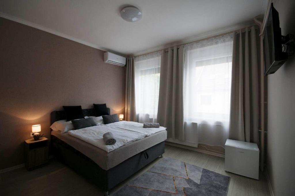 1 dormitorio con cama y ventana grande en Noel Vendégház, en Szeged