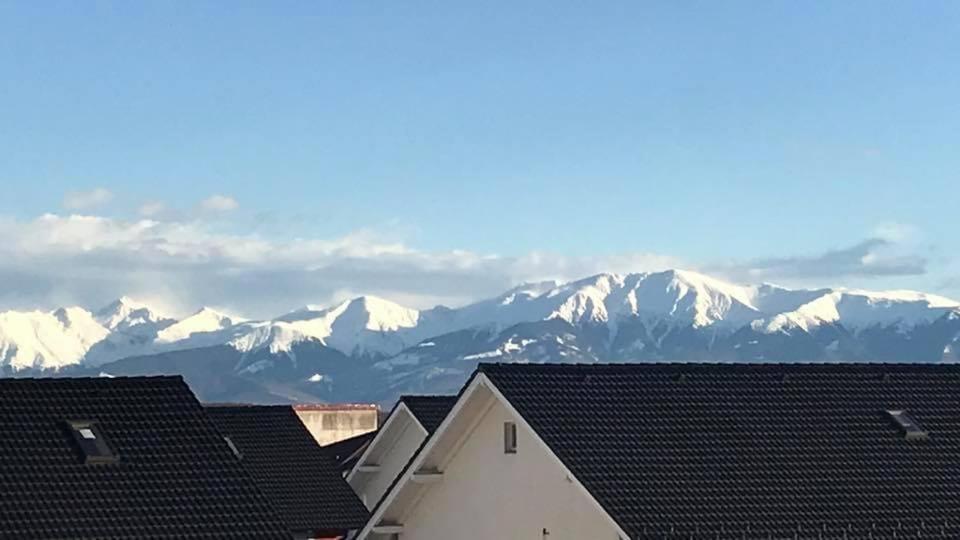 a view of snow covered mountains from roofs of houses at Panorama penthouse in Şelimbăr