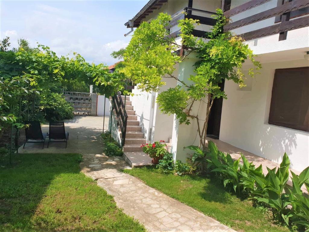 a courtyard of a house with trees and flowers at Villa Sofia in Chernomorets