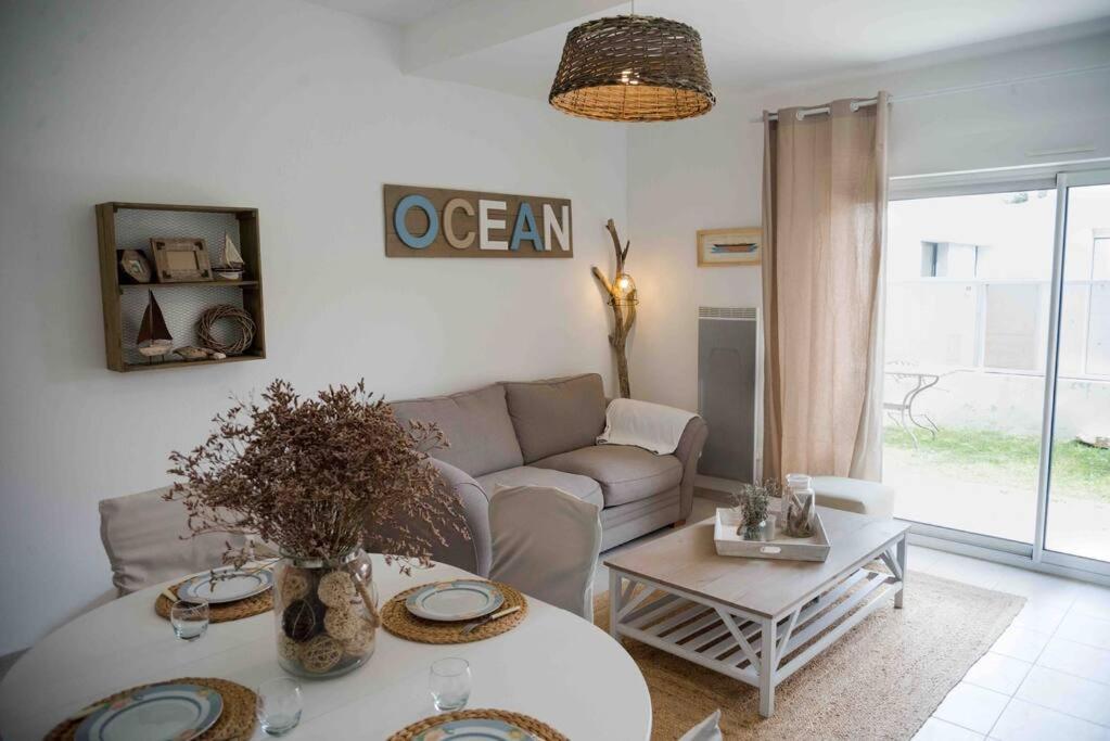 a living room with a couch and a table at Appart cosy 4/6 personnes idéalement placé in Aytré