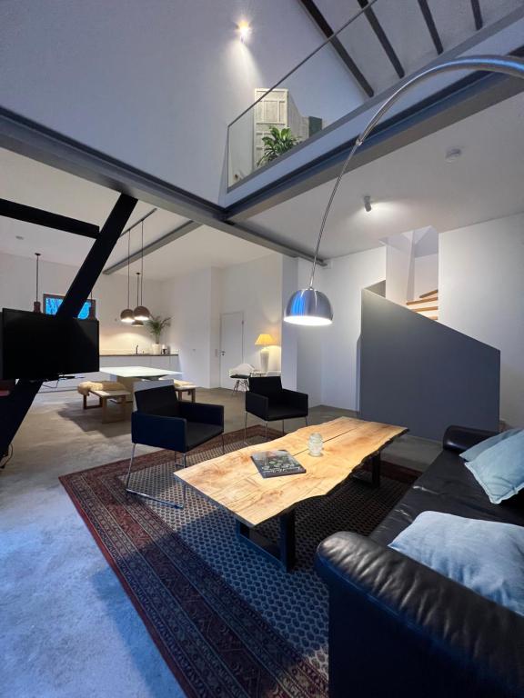 a living room with a table and a couch at Historisches Designer Loft in Essen