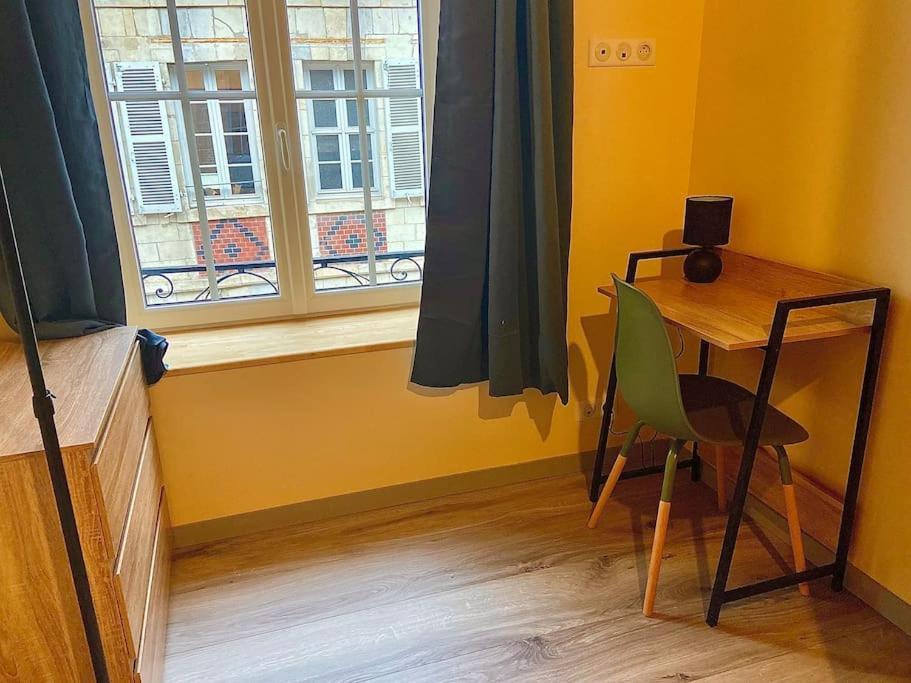 a room with a desk and a chair and a window at Cathédrale in Moulins