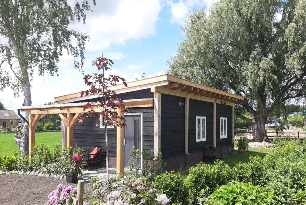 une petite maison avec un kiosque dans un jardin dans l'établissement Bed & Breakfast Bij de Wilg, à Laren