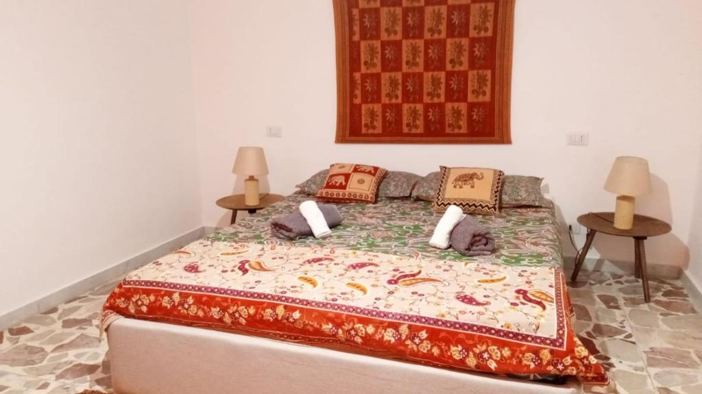 1 dormitorio con 1 cama grande y 2 mesas en Kasakarma, en Agira