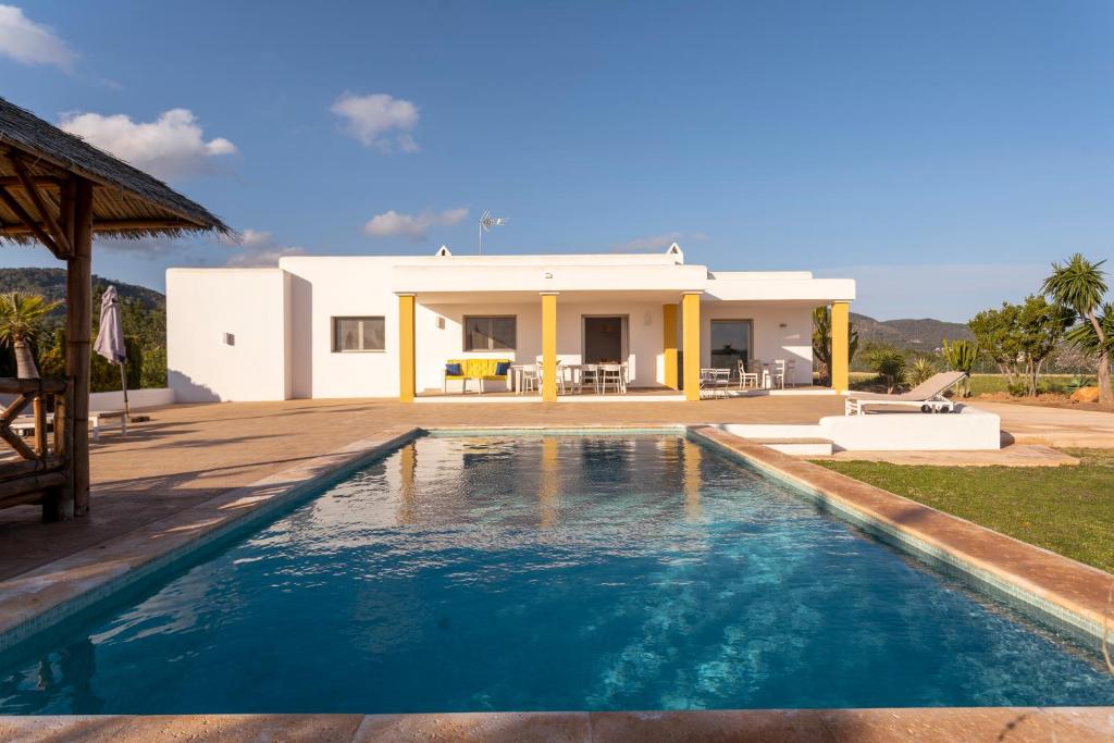 a villa with a swimming pool in front of a house at Villa con piscina Ibiza centro in Sant Josep de sa Talaia