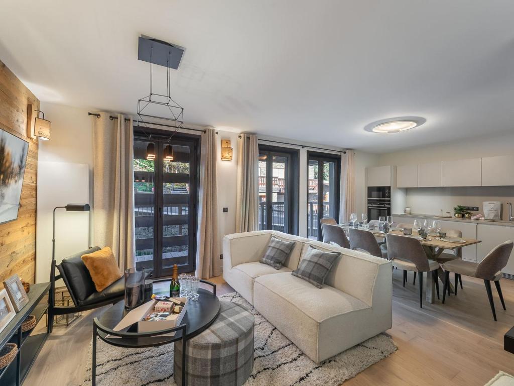 un salon avec un canapé et une table dans l'établissement Duplex Neuf Près des Pistes avec Cheminée, Parking et Wifi Inclus - FR-1-562-72, à Courchevel