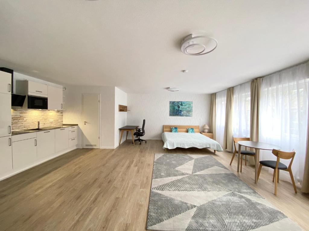eine Küche und ein Wohnzimmer mit einem Tisch und einem Bett in der Unterkunft Sehr zentral, geräumiges, helles Studio-Apartment in Köln