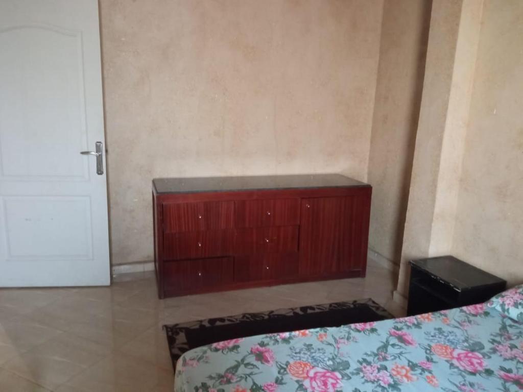 1 dormitorio con cama y tocador de madera en Aya house, en Agadir