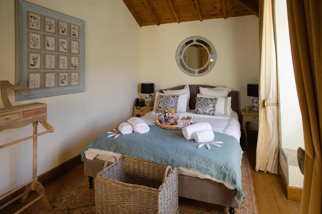 a bedroom with a bed with towels and a mirror at Suites at the Villas by Quinta da Bella Vista in Sintra