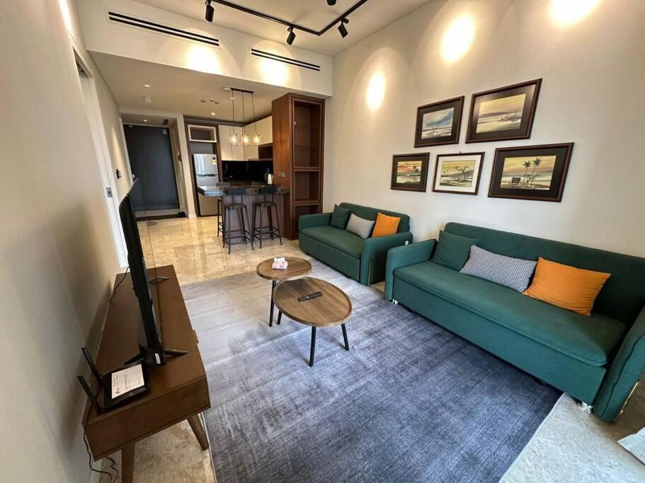 a living room with a green couch and a table at Anggun Residence Walking distance 5-10mins to Sogo Chow Kit Monorail and LRT station by Juststay in Kuala Lumpur