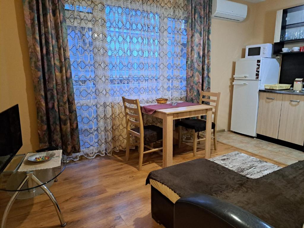 salon ze stołem oraz kuchnia z lodówką w obiekcie Arda Riverside Apartment w mieście Kyrdżali