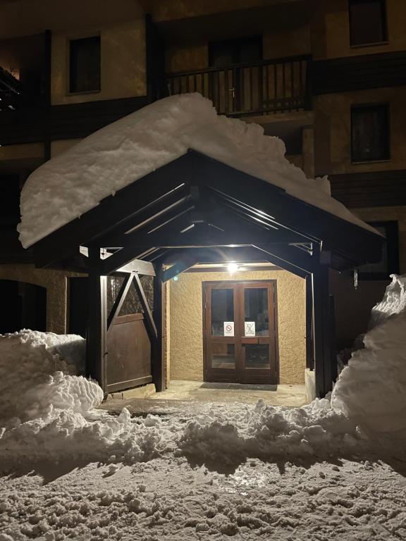 une petite maison couverte de neige la nuit dans l'établissement Studio cosy 1700, à Puy-Saint-Vincent