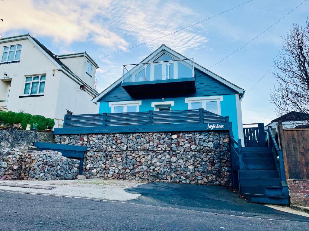 a blue house on top of a stone wall at Ingledene in Brixham