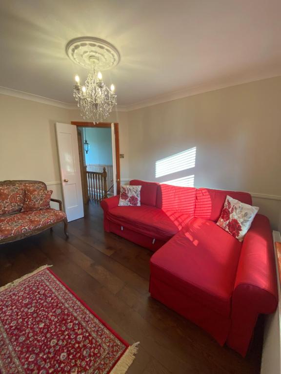 ein Wohnzimmer mit zwei roten Sofas und einem Kronleuchter in der Unterkunft NEW LISTING Faye’s Place in Donegal