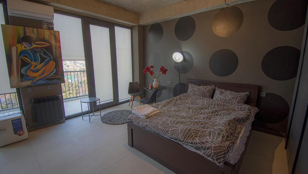 een slaapkamer met een bed en een schilderij aan de muur bij Villa Residence Apartment in Tbilisi City