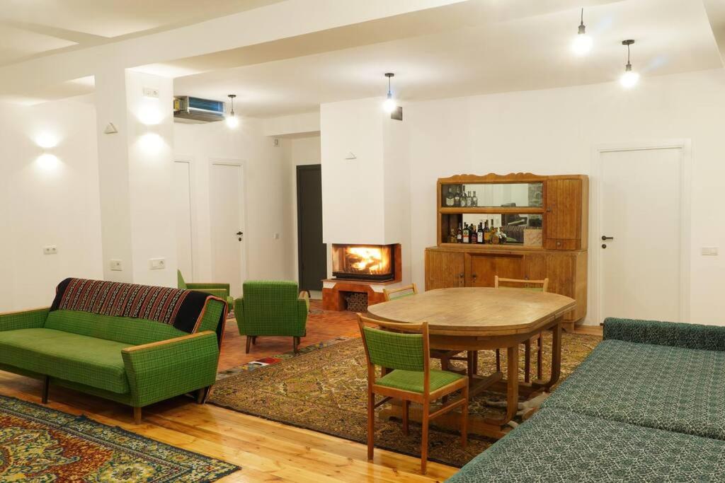a living room with a table and chairs and a fireplace at Your villa with garden in Martuni next to Sevan lake in Martuni