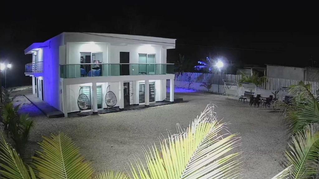 a white house with blue lights on it at night at Cabaña los Abuelos in Coveñas