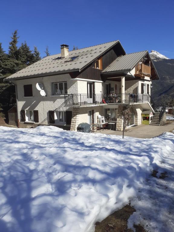 una casa grande con nieve delante en La Grande Lauze, en Champcella