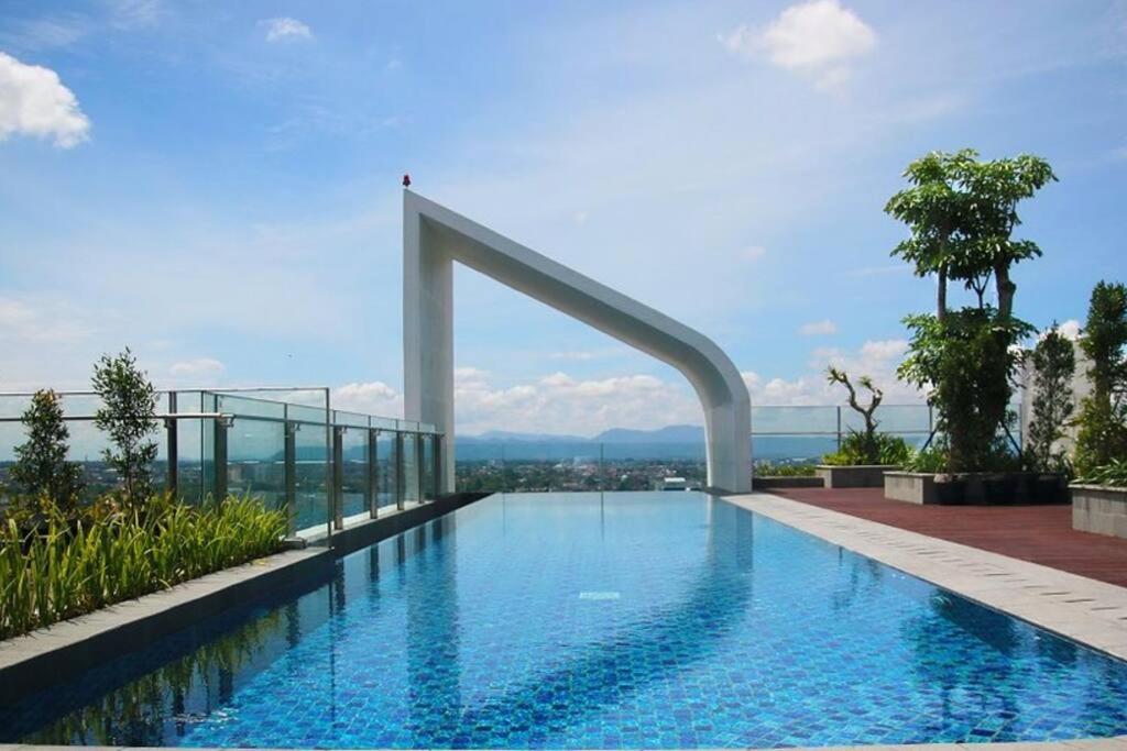 a swimming pool on top of a building at Apartemen Uttara with Mountain View City Center in Kejayan