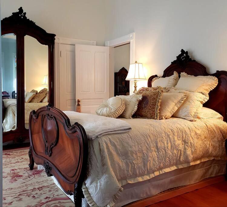 een slaapkamer met een groot bed en een grote spiegel bij The Queen On Main in Winters