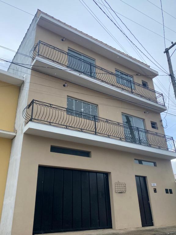 aominium building with a balcony with black doors at Apartamentos C7 in Cunha